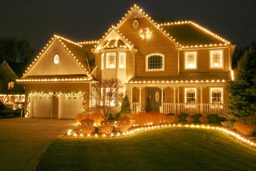 Home outlined in warm white lights with lit landscaping